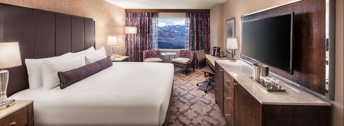 Silver Legacy Deluxe Spa Suite – 1 King at Silver Legacy Resort Casino — bedroom with premium bedding