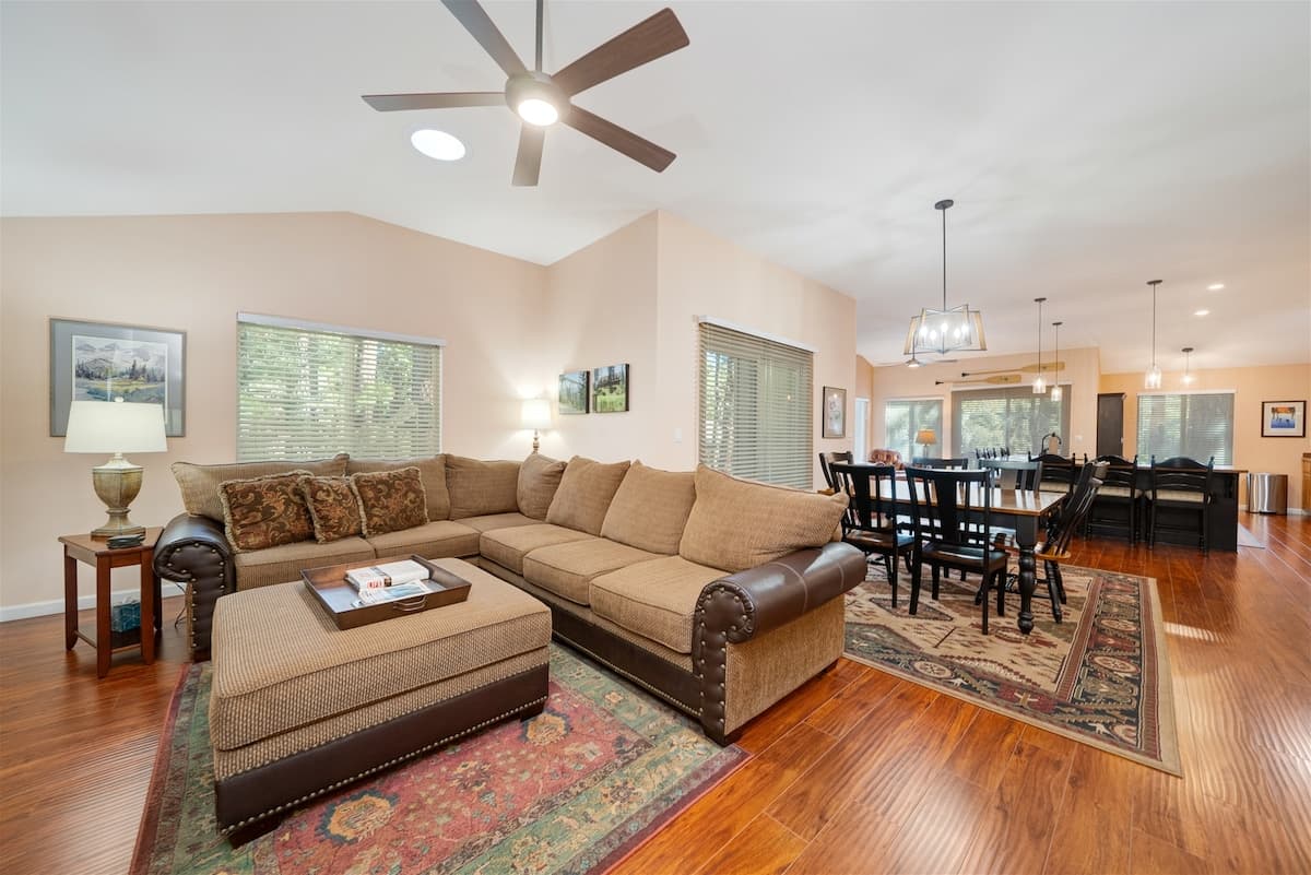 Open living and dining with a sectional, vaulted ceiling and cherry hardwood floors at 114 Cottonwood, Plumas Pines — 3-bedroom Plumas Pines vacation rental in Graeagle, CA