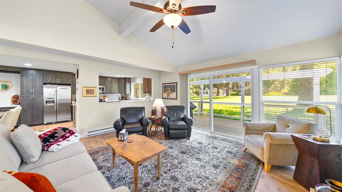 Living room with a vaulted beamed ceiling and sliders onto the deck over the 5th fairway at 38 Aspen, Plumas Pines — 4-bedroom Plumas Pines vacation rental in Graeagle, CA